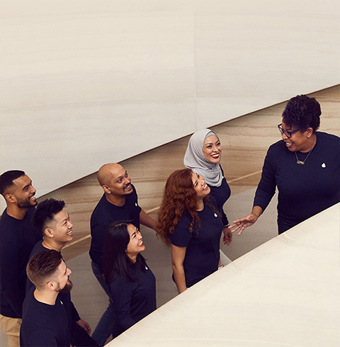 Teammitglieder, die in einem Apple Store die Treppe hinaufgehen.