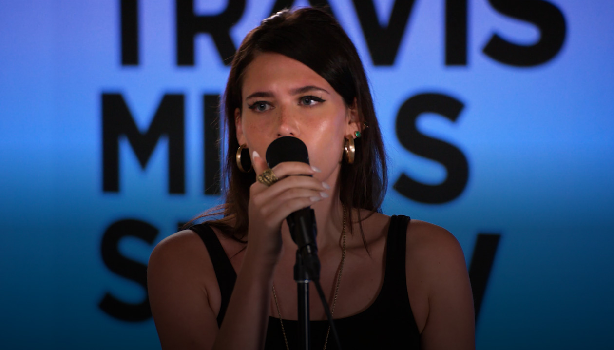 Sienna Spiro singing into a microphone