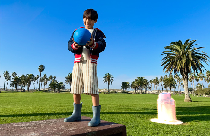 A picture of a person leaning against a wall. Clean Up removes a traffic cone from the final image
