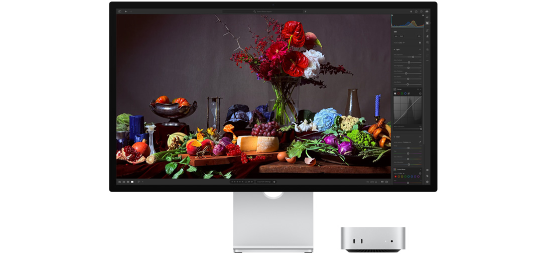 Imagen de alto contraste de una mesa con varios platos de comida y un ramo de flores sobre un fondo oscuro, se muestra cómo True Tone ajusta la temperatura del color.